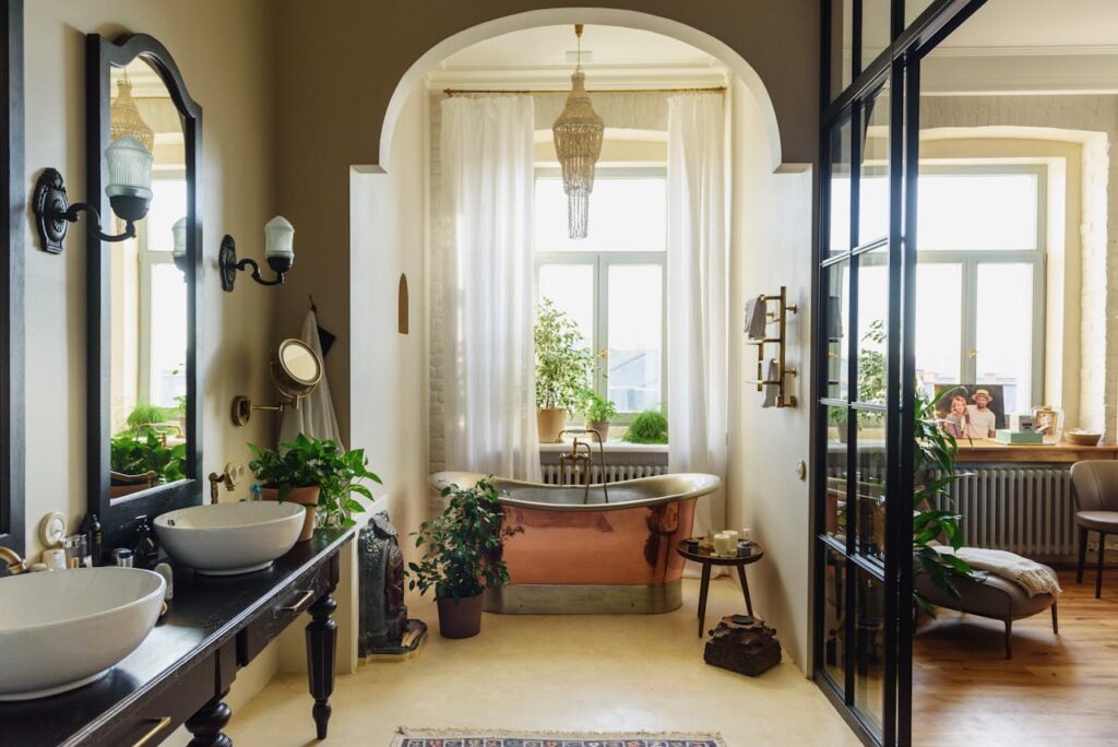 A gorgeous bathroom with a copper soaking tub, vessel sinks, and lots of natural light. Here are some tips on how you can create a luxurious retreat at home.