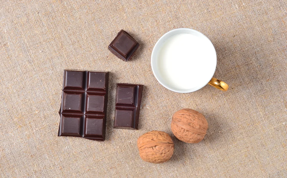 Pieces Dark Chocolate Walnuts Cup Milk Sackcloth — Stock Photo, Image