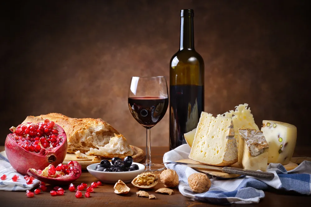 Red Wine Cheese Walnuts Olives Pomegranate Bread Rustic Setting Space — Stock Photo, Image