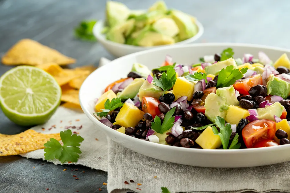 Avocado, mango salad with black bean, tomato, red onion and tortilla chips. healthy food — Stock Photo, Image
