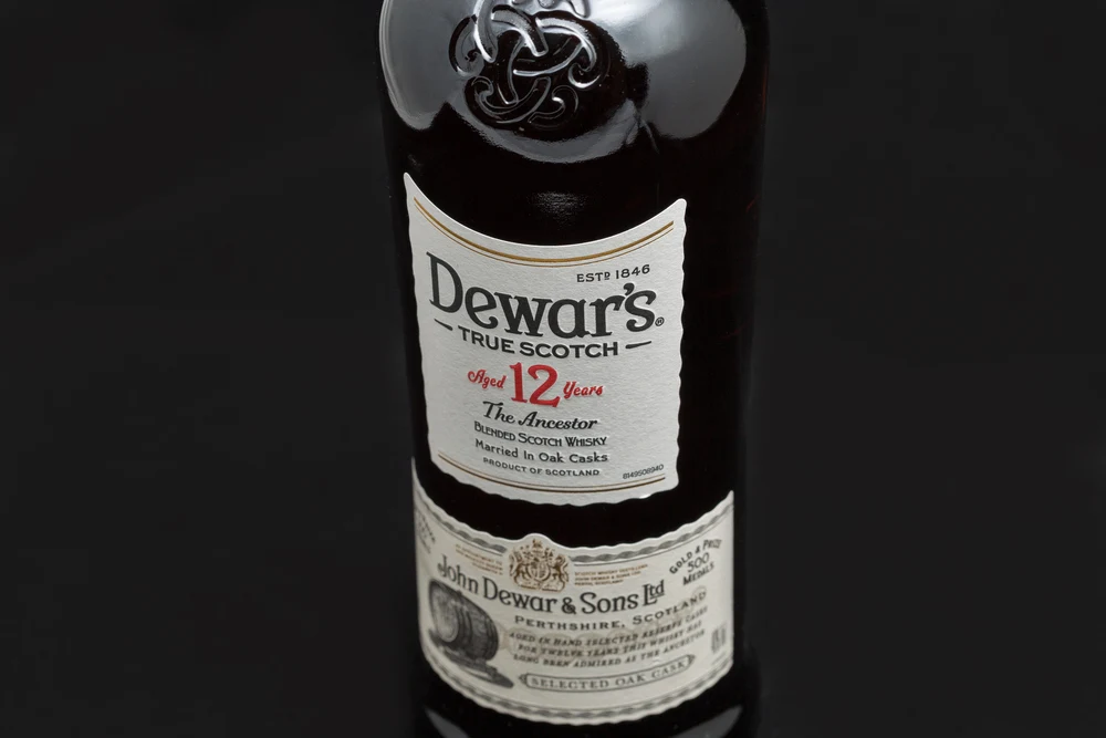 KYIV, UKRAINE - AUGUST 17, 2019: Dewar's True Scotch The Ancestor aged 12 years blended Scotch Whisky label closeup. Dewar's whiskies have won more than 400 awards and medals in over 20 countries. — Photo by panama7