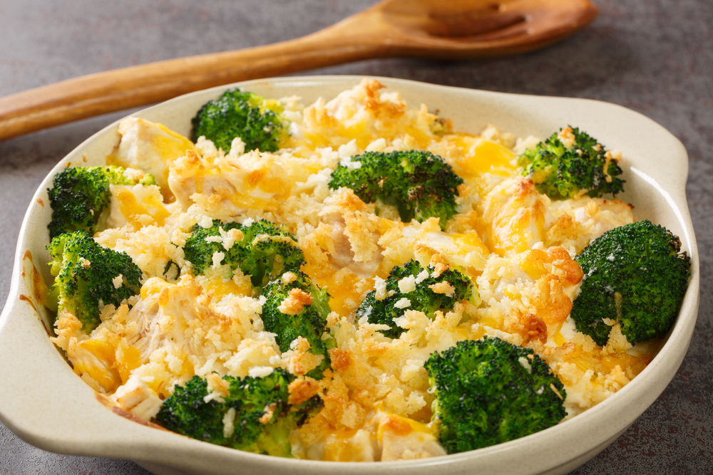 Chicken Divan is a type of chicken and broccoli casserole with a creamy sauce close up in the dish on the old table. Horizontal