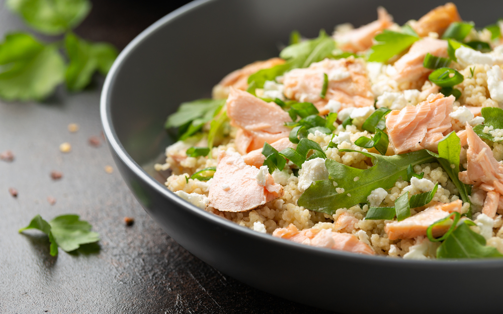 Salmon Couscous salad with feta cheese dressing and herbs. healthy food. — Stock Photo, Image