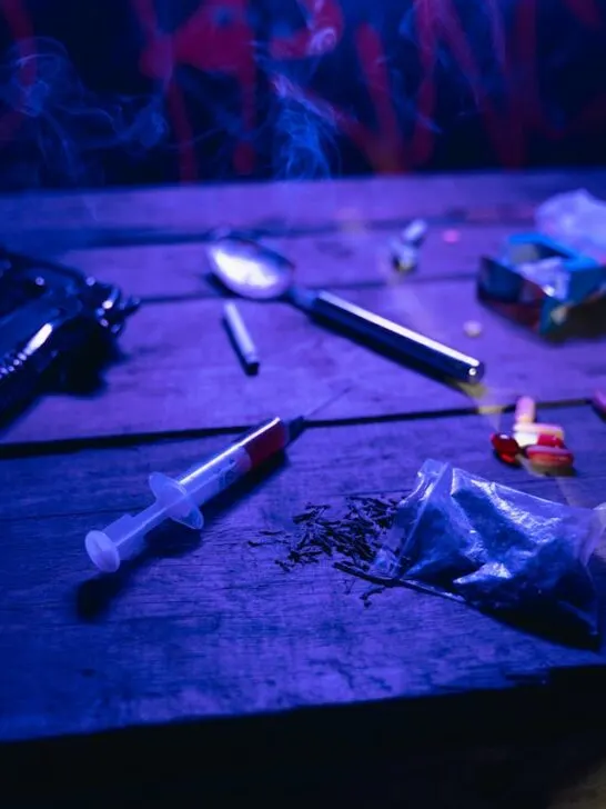 A table covered with pills and syringes and a handgun - ley parts of addiction. Today there are many ways to beat opioid addiction.