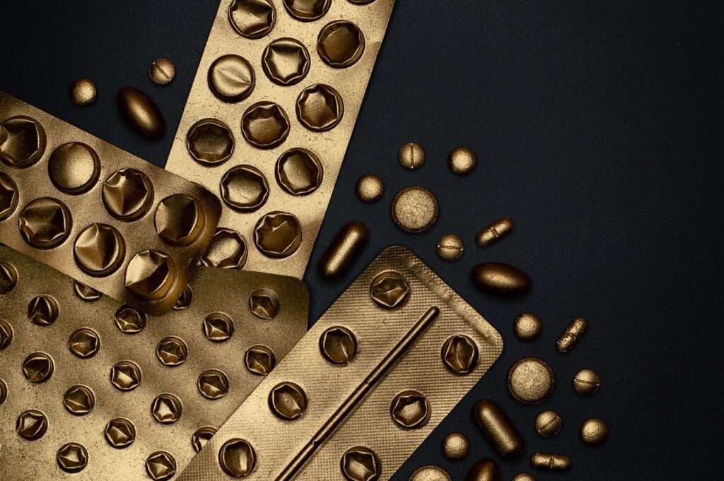 gold pill packets on a black background