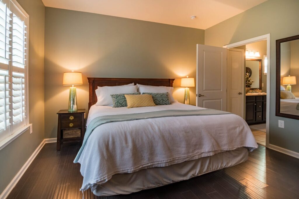 A made up bed in a bedroom with pillows and a comforter. Choosing the best mattress firmness directly impacts the quality of sleep.