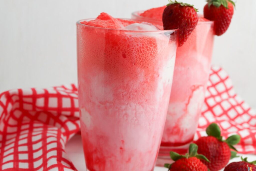 Two strawberry ice cream floats garnished with fresh strawberries