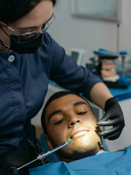 A man in a dentists chair about to have his teeth checked and cleaned