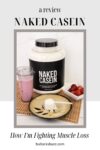 A jug of Naked Casein next to a cup of strawberry smoothie, a bowl of strawberries and a plate with a large scoop of Naked Casein protein powder