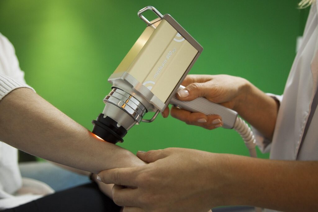 A doctor using a tool for skin cancer on a patients arm
