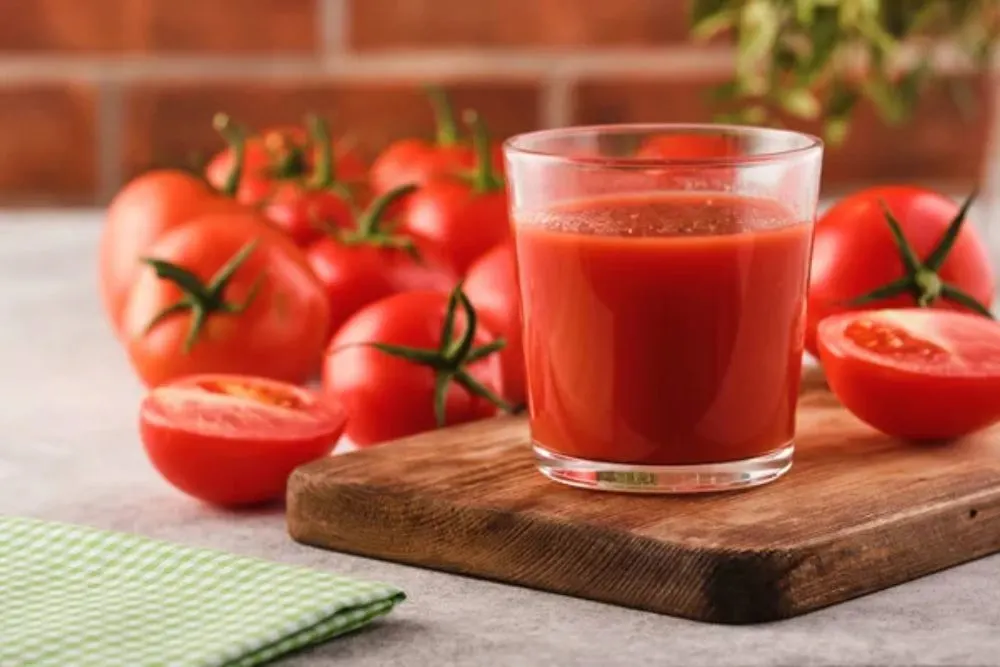 Tasty Tomato juice in a glass with ripe red tomatoes. — Photo