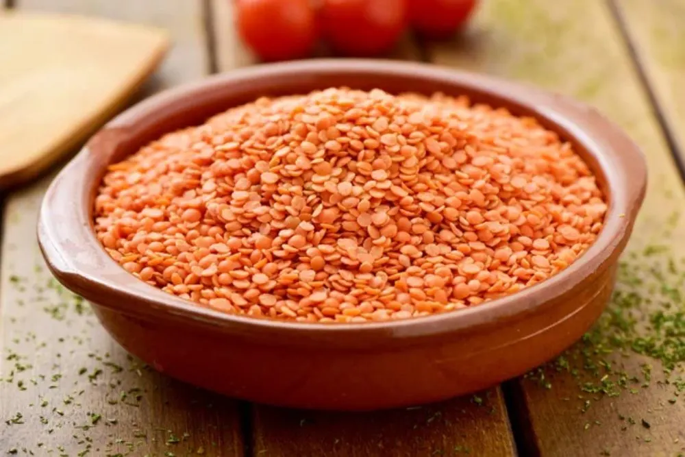 Uncooked red lentils in an earthenware bowl — Photo