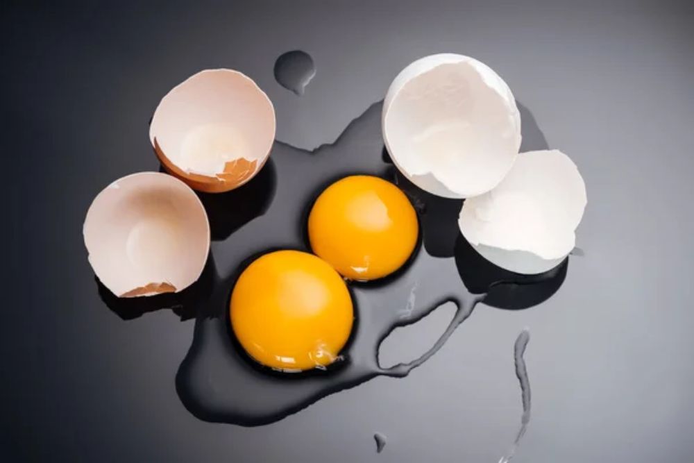 Top view of raw smashed chicken eggs with yolks
