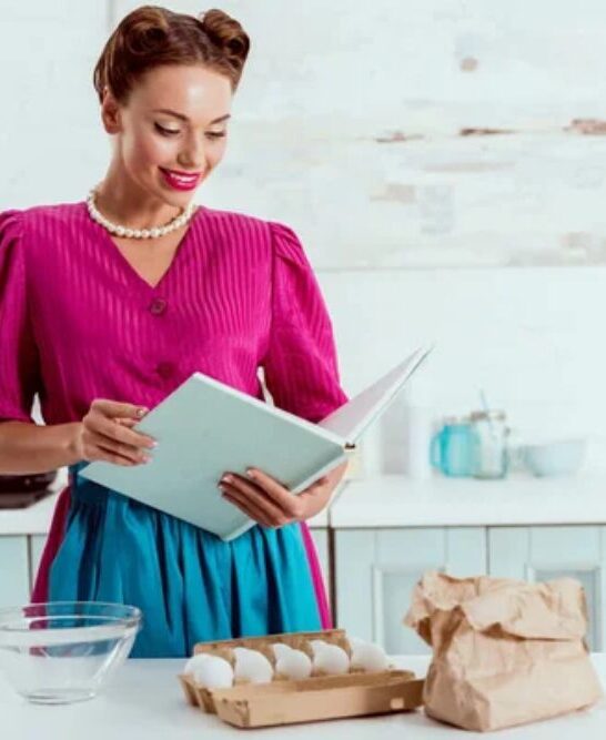 Elegantly dressed pin up girl reading recipes book — Photo