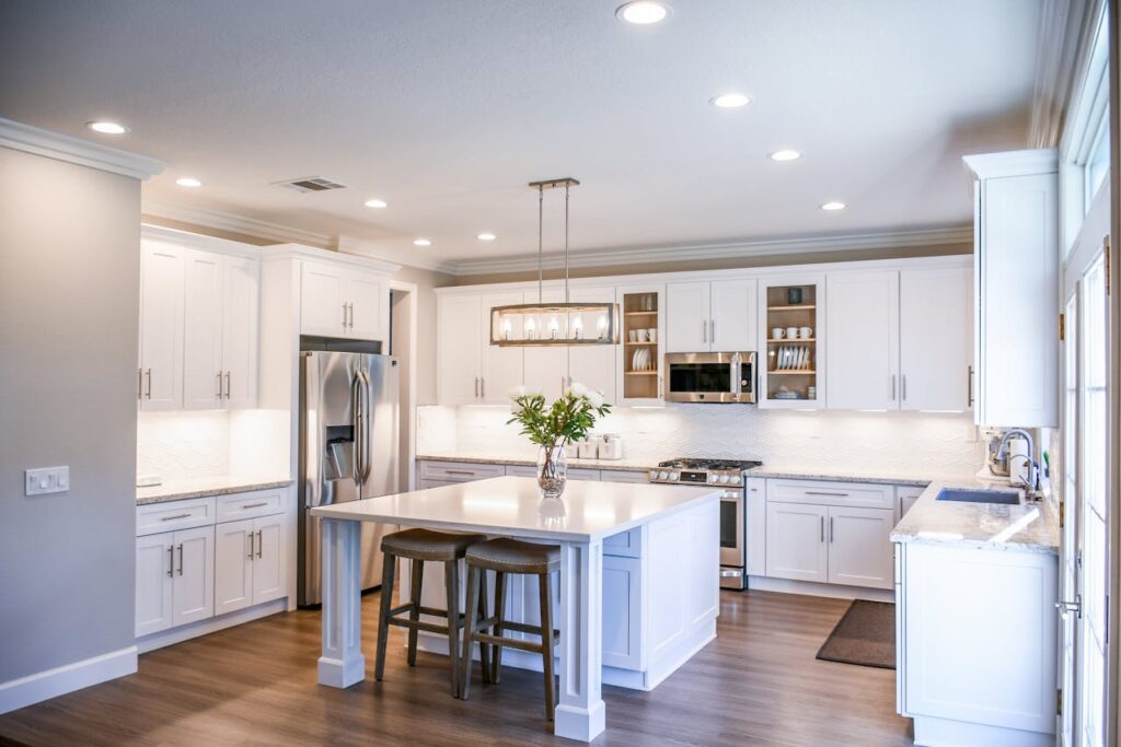 A white modern kitchen with a pretty box light.  Changing lighting fixtures is a simple way to refresh your home on a budget.