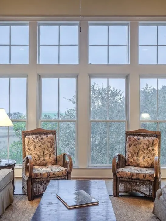 A large group of floor to ceiling windows in a living room that will be expensive when it comes time to decide whether to go with window replacement or repair