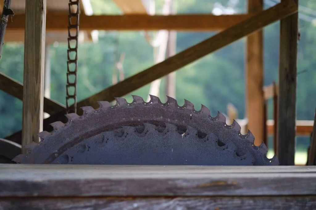 Close up of a saw used to cut trees into lumber for one of many uses as sustainable wood in building projects