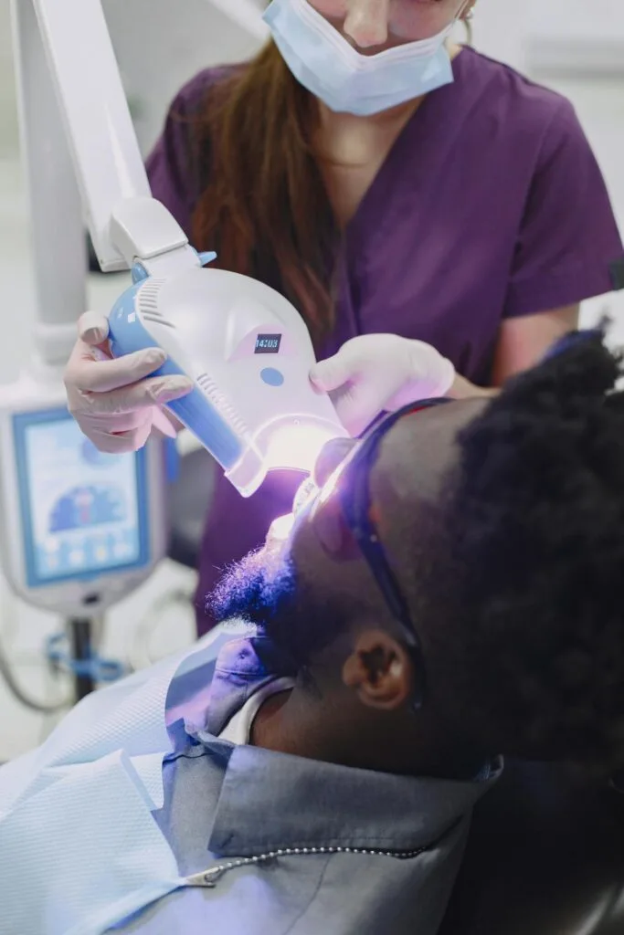 a man in the dentist's chair having his teeth whitened using the latest technology
