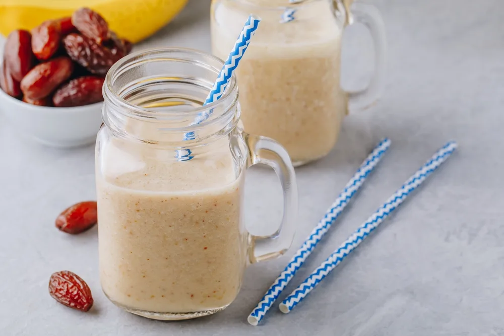 Banana and date fruit smoothie or milkshake in glass