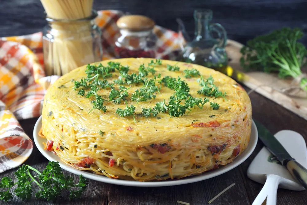 Spaghetti pie with lard and cheese, parsley dressing — Photo