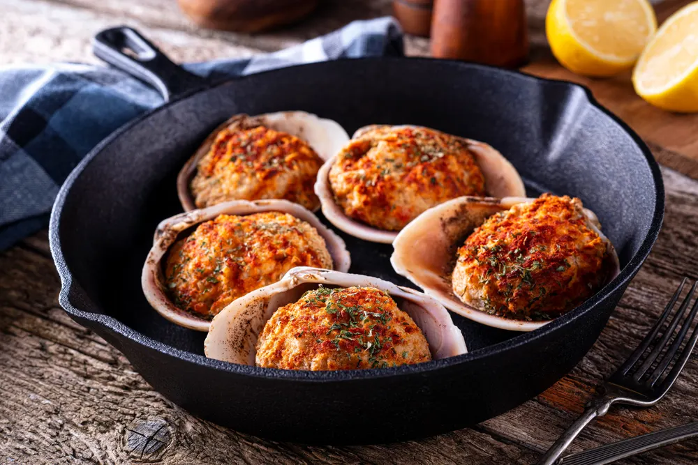 Delicious oven baked stuffed clams on a rustic wood table