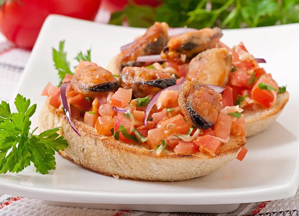 Bruschetta with mussels, cheese and tomatoes — Photo