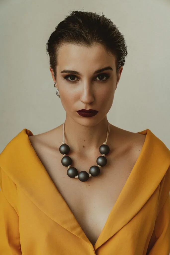 A woman wearing a necklace of black pearls