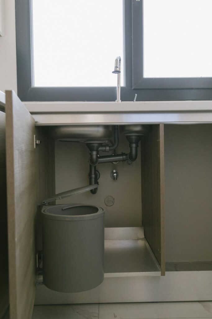 A bucket under a sink to catch leaking water