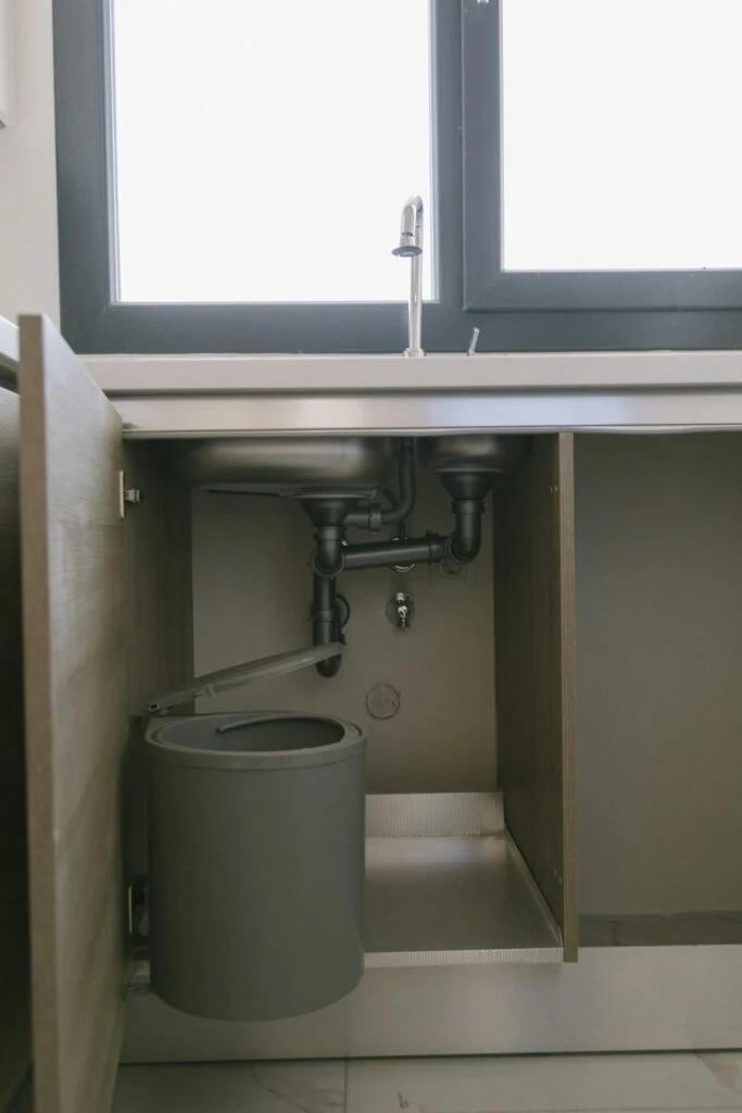 A bucket under a sink to catch leaking water
