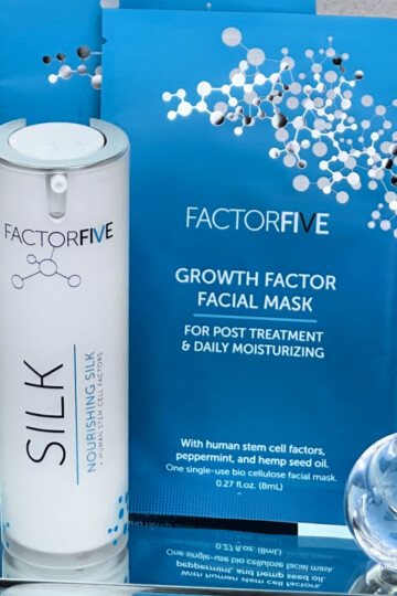 Close up of both FactorFive Skincare products on a mirrored tray with a crystal perfume bottle next to them