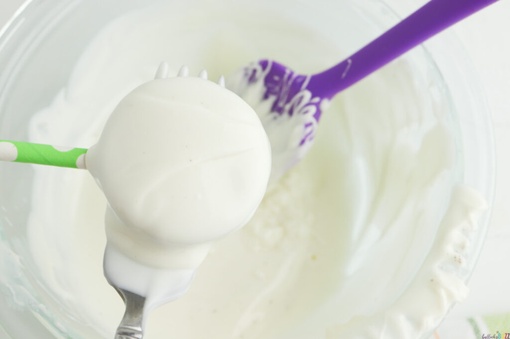 An Oreo covered in white chocolate after being dipped