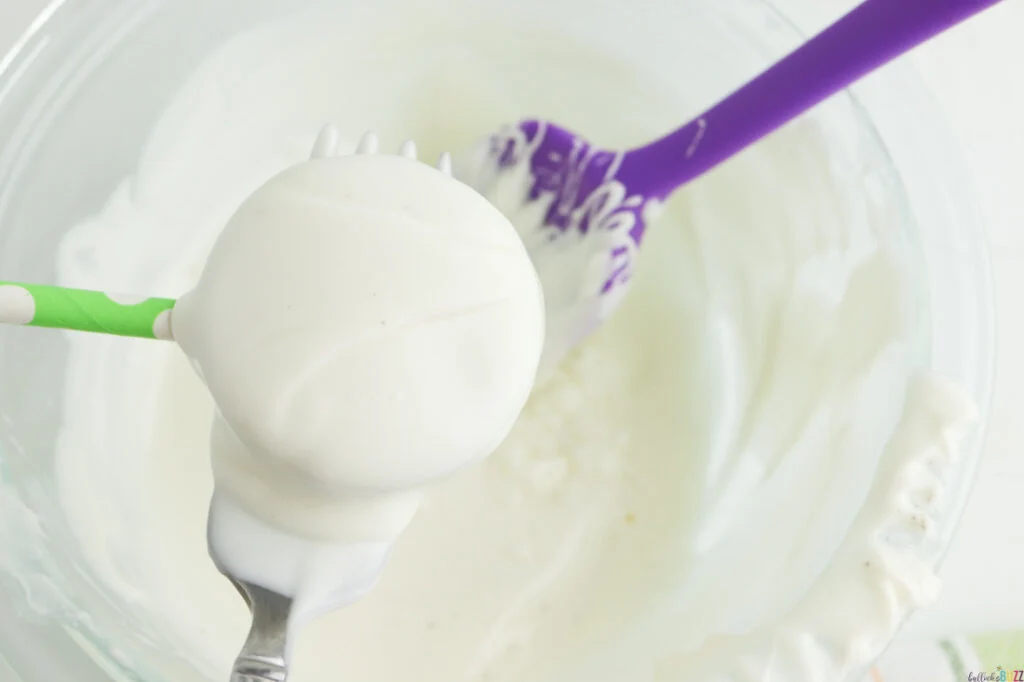 An Oreo covered in white chocolate after being dipped