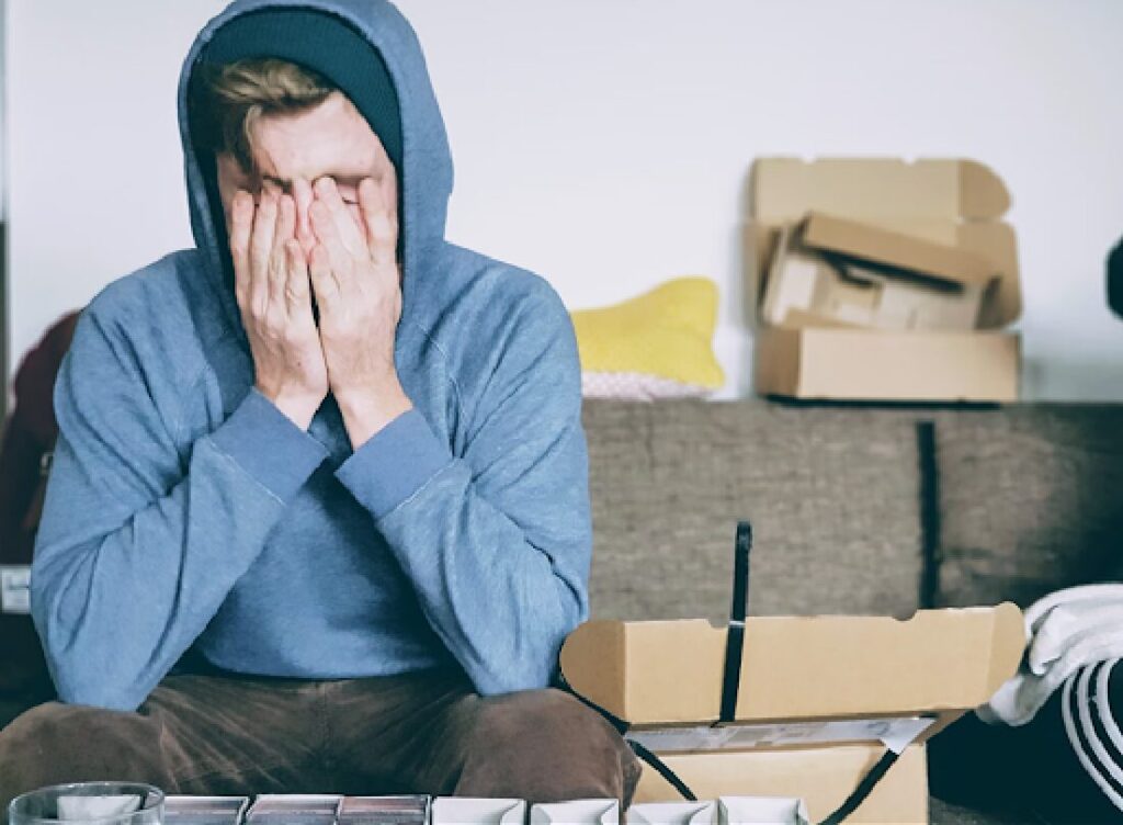 A man sitting down holding his head in his hands while considering hiring the best Title IX lawyer