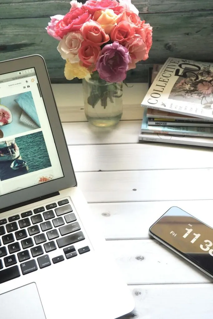 A laptop cell phone on magazines on a white background