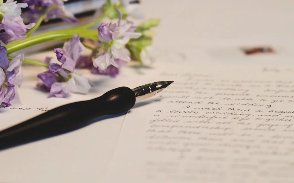 a calligraphy pen on a piece of paper with writing