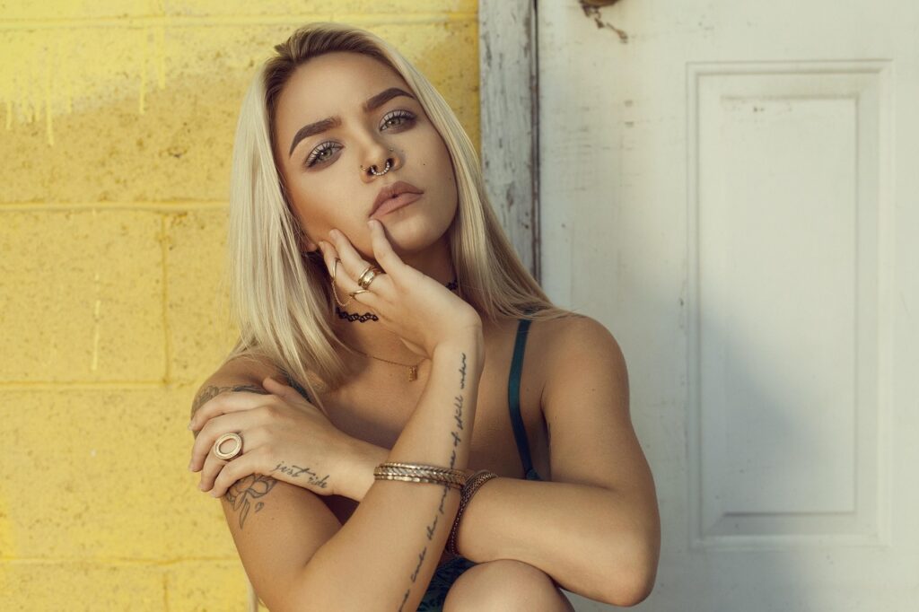 A blonde model in front of a yellow wall