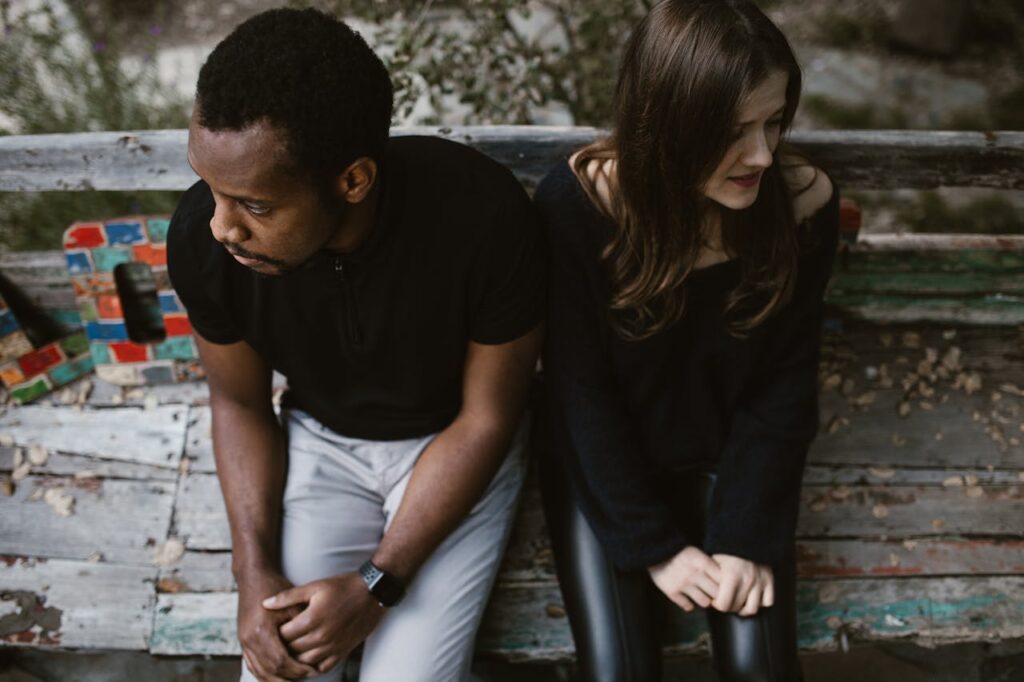 A couple sitting next to each other but looking in opposite directions. Divorce can be painful, so use these tips on protecting your mental health during divorce