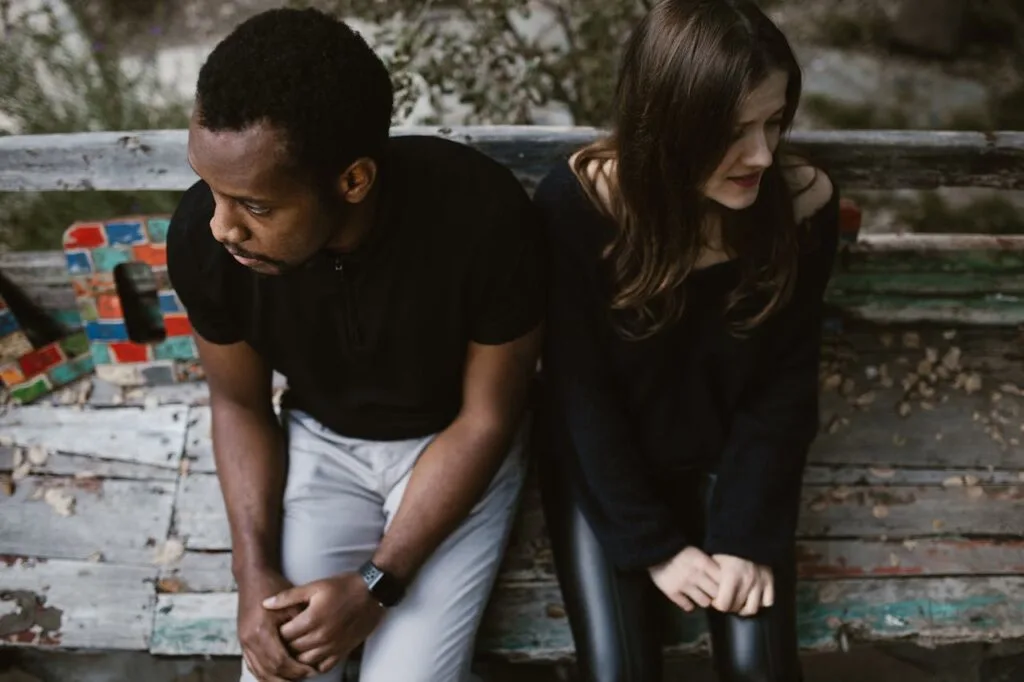 A couple sitting next to each other but looking in opposite directions. Divorce can be painful, so use these tips on protecting your mental health during divorce
