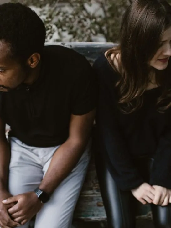 A couple sitting next to each other but looking in opposite directions. Divorce can be painful, so use these tips on protecting your mental health during divorce