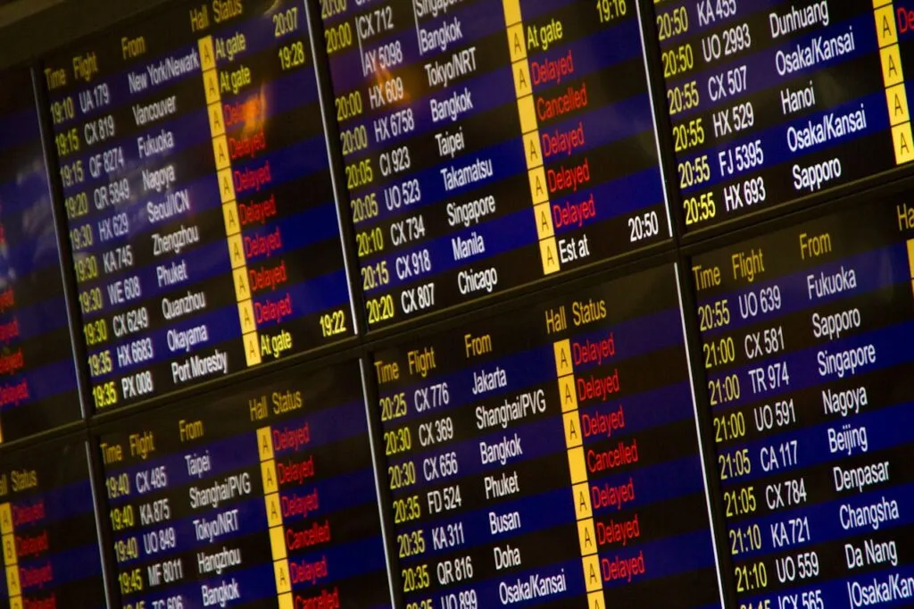 A flight board at an airport showing many flights and destinations, all part of travel planning