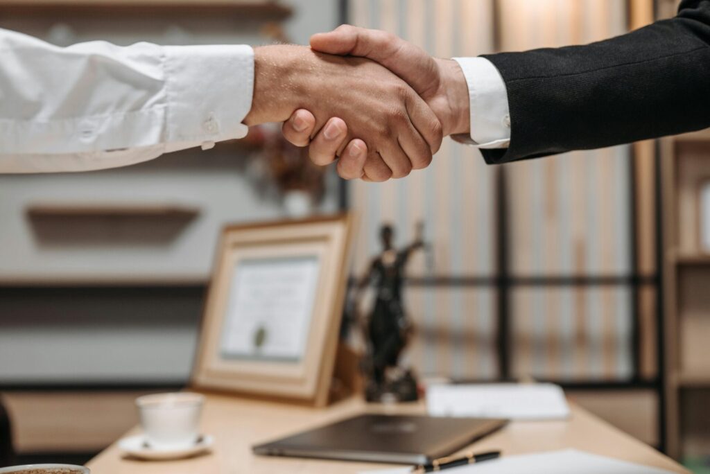 two men shaking hands over trusts and wills