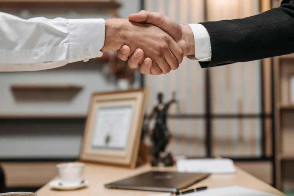 two men shaking hands over trusts and wills