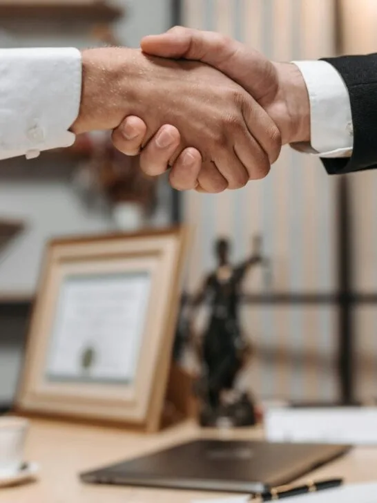 two men shaking hands over trusts and wills