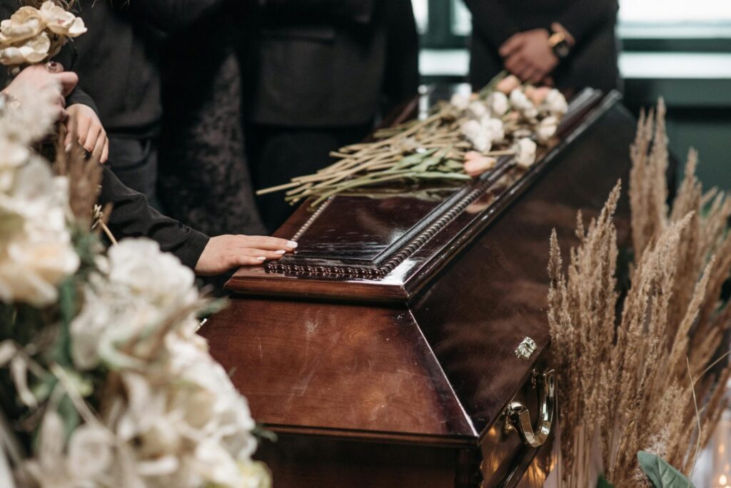 A person with their hand on a casket