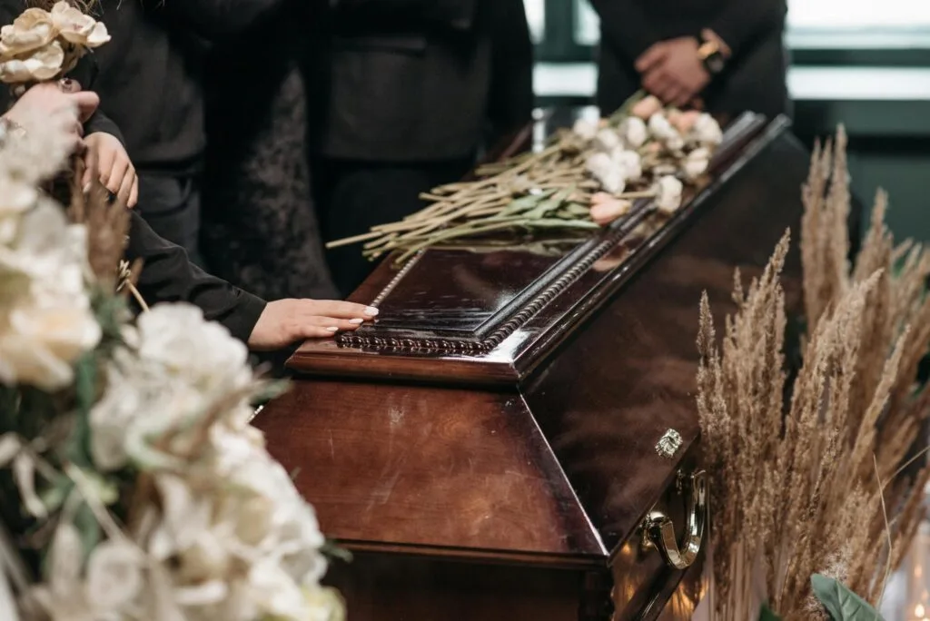 A person with their hand on a casket