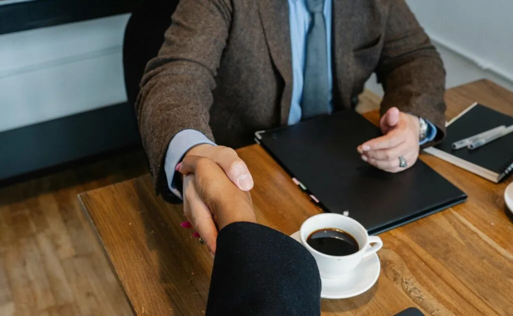 Men shaking hands over a desk