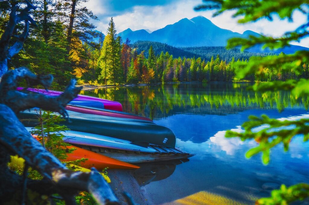 Canoes on the side of a lake with a mountain in the distance