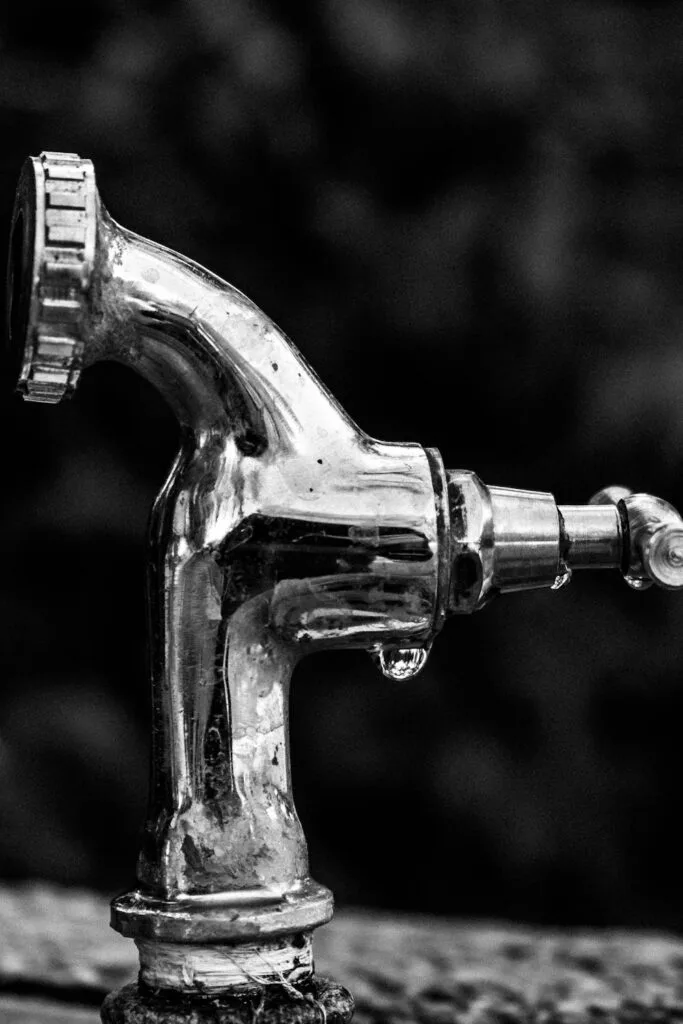 Close up of a leaking faucet. There are many ways to detect a water leak in your house to prevent damage.