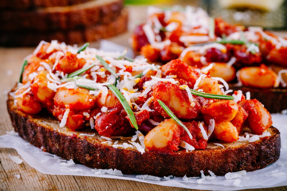 Bruschetta with baked beans in tomato sauce with rosemary — Stock Photo, Image
