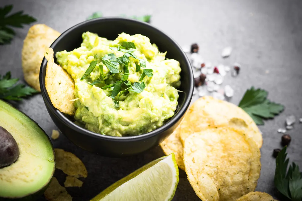 Traditional latinamerican mexican sauce guacamole and chips on b — Stock Photo, Image